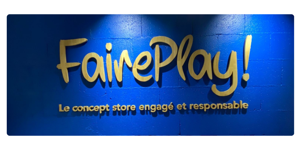 Enseigne en lettres découpées en bois naturel sur mur bleu, réalisée pour un concept store engagé et responsable